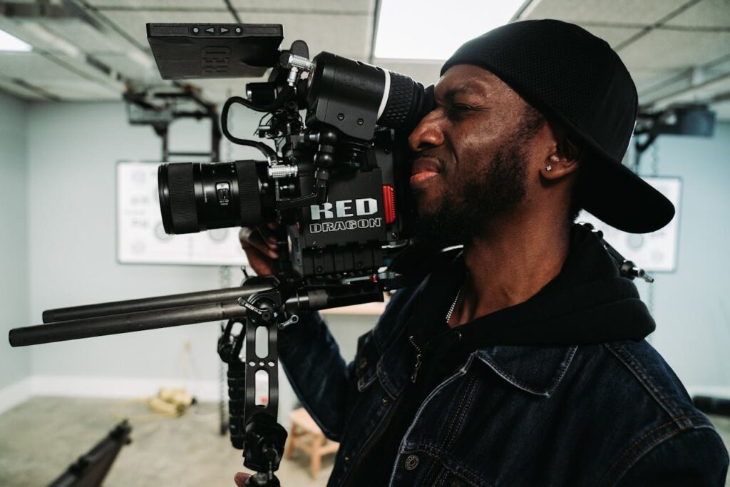 Man in Denim Jacket Holding Black Video Camera